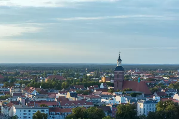 Luftbild über Berliner Wohnhäuser und Kirche, mit blauem Himmel