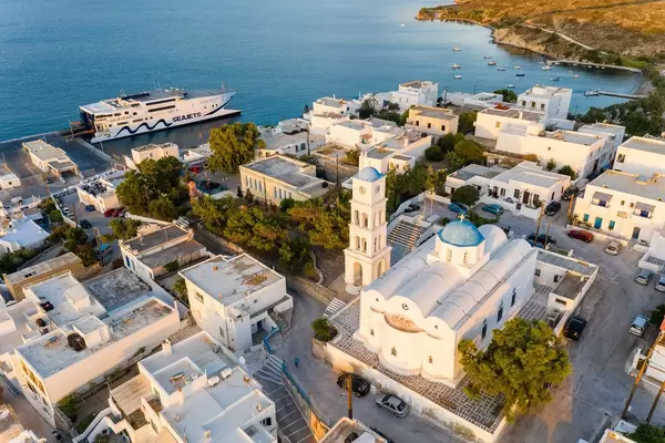 Luftbild von Adamantas auf Milos mit weißer Kirche und Glockenturm mit den typischen blauen Kuppeln