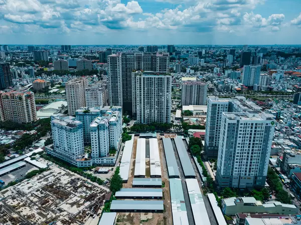Luftbild von Apartmentgebäuden, einer Baustelle und einem großen Parkplatz in Distrikt 4 in Ho Chi Minh Stadt, Vietnam