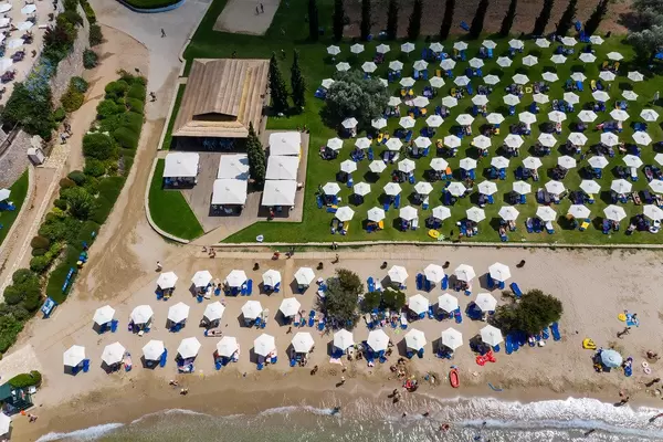 Luftbild von Menschen am Strand Hinitsa nahe Porto Heli, mit aufblasbaren Luftmatratzen und Wasserspielzeug