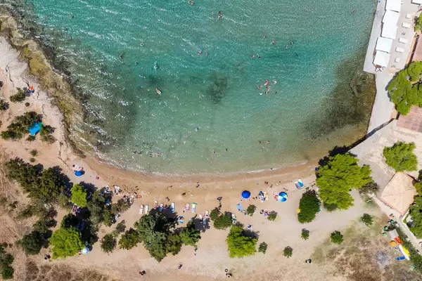 Luftbild von Touristen am Sandstrand Hinitsa in der Urlaubsregion Porto Heli, Griechenland, am Argolischen Golf