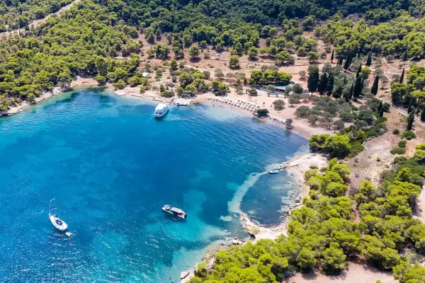 Luftbild zeigt das blaue Wasser des Argolischen Golfs vor dem Urlaubsstrand  Zogeria auf Spetses, Griechenland