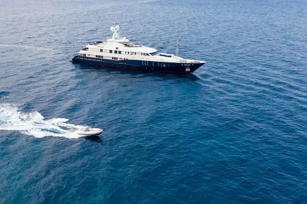 Luftbild zeigt ein Sportboot beim Überholen der luxuriösen Turqoise Yachts Motoryacht "Rare Find" auf dem Argolischen Meer, mit einem Innendesign von H2 Yacht Design