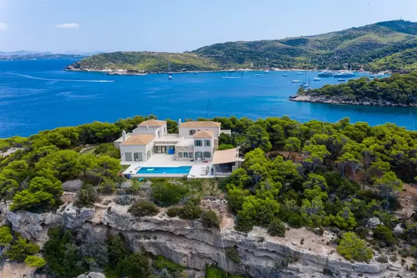 Luftbild zeigt eine mediterrane Villa mit Pool in der Natur, auf einer Felsenklippe der griechischen Insel Spetses