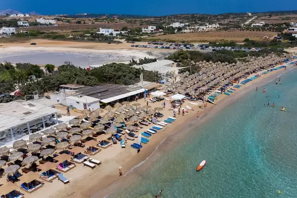 Luftbild zeigt Santa Maria Strand voller Touristen im Sommerurlaub, unter Sonnenschirmen aus Bast