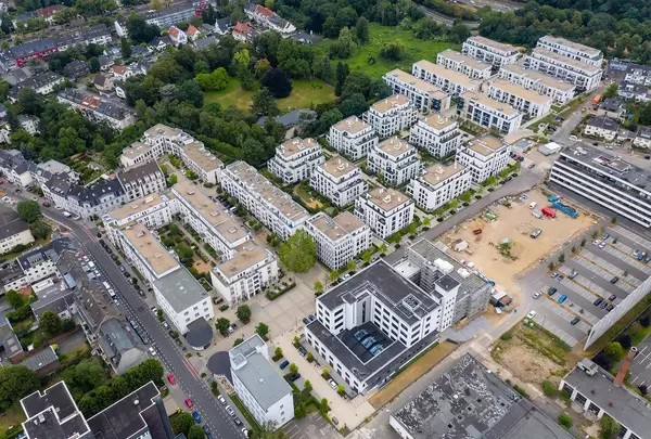 Luftbildaufnahme von neuen Mehrfamilienhäusern im Wohnquartier Park Linne, neben einer Baustelle in Köln Müngersdorf