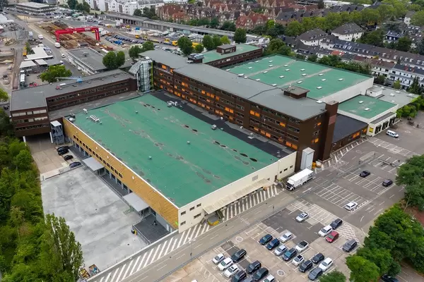 Luftbildfotografie eines Rewe Supermarkts mit grupnem Flachdach und Parkplatz an der Stolberg Straße 92 in Köln