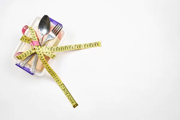 Lunchbox tied with measuring tape. Concept of weight loss