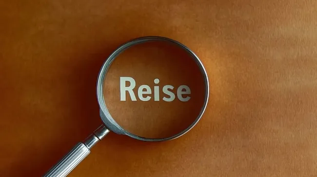 Lupe fokussiert auf das Wort 'Reise' - Konzept für Reiseplanung