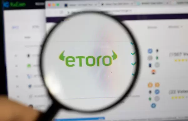 Lupe über dem Etoro-Logo auf dem Bildschirm