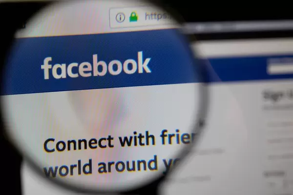 Lupe über dem Facebook-Logo auf dem Bildschirm