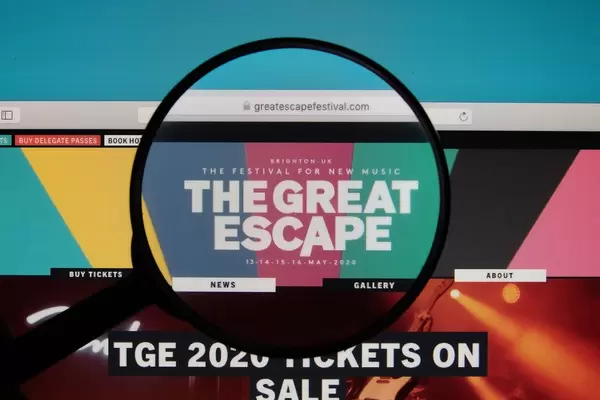 Lupe über dem Logo der Internetseite des Great Escape Festivals