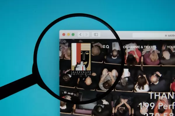 Lupe über dem Logo der Internetseite des Salzburg Festivals