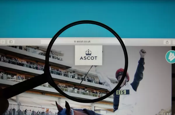 Lupe über dem Logo der Internetseite von Royal Ascot