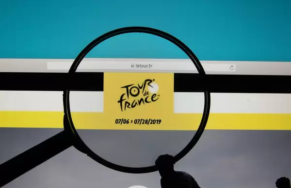 Lupe über dem Logo der Internetseite von Tour de France