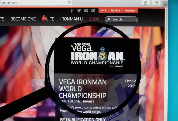 Lupe über dem Logo und Schriftzug der IRONMAN Weltmeisterschaft