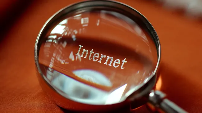 Lupe zeigt das Wort 'Internet' - Digitale Vernetzung im Fokus