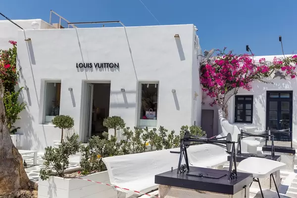 Luxury shopping in Mykonos: Louis Vuitton shop in a white building with plants and open-air terrace