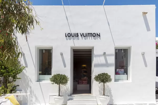 Luxus-Shopping auf Mykonos: Louis Vuitton Laden in weißem Gebäude mit Pflanzen vor dem Eingang