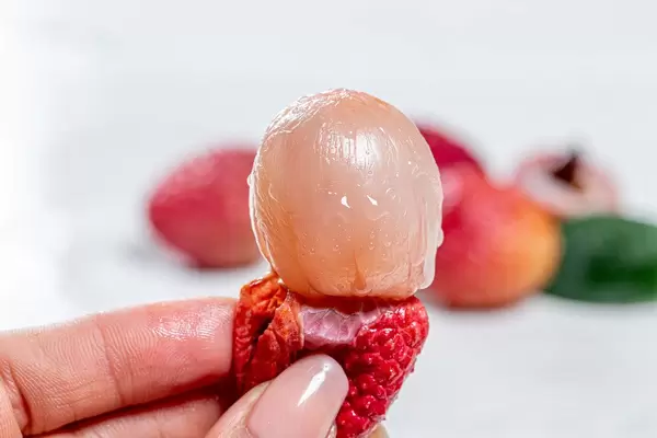Lychee fruit pulp without peel in a woman's hand