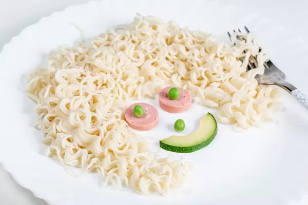 Macaroni for children. Serving a dish in the form of a smiling head