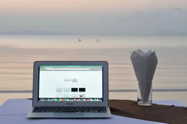 MacBook Air mit geöffneter Google-Suche, Meer im Hintergrund