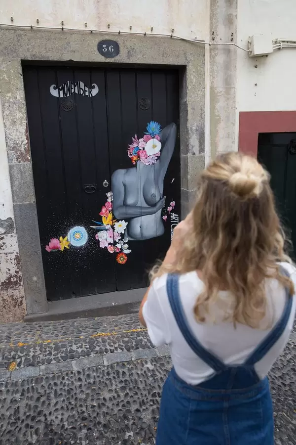 Mädchen fotografiert interessante Straßenkunst auf Madeira