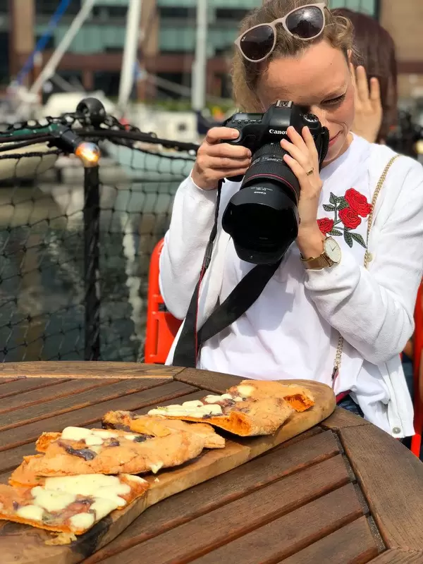 Mädchen fotografiert Nahrung mit Spiegelreflexkamera