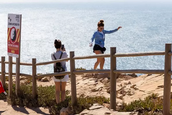 Mädchen machen waghalsige Fotos an den Klippen von Cabo da Roca