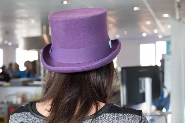 Mädchen trägt einen violettfarbenen Zylinderhut