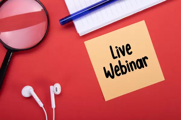 Magnifier, headphones and note with Live Webinar text on red background
