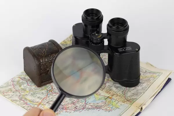Magnifying glass and binoculars on old map