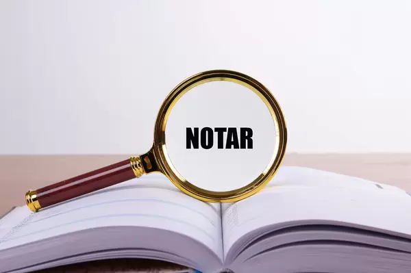Magnifying glass and book with Notar text