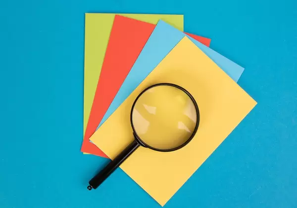 Magnifying glass on colorful papers