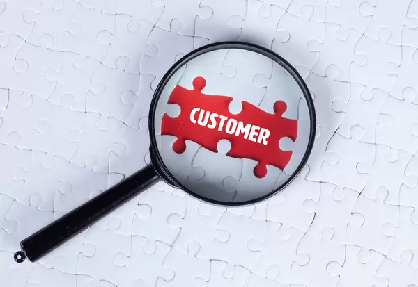 Magnifying glass over missing puzzle with a text Customer
