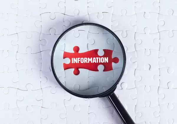 Magnifying glass over missing puzzle with a text Information