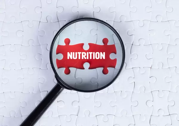Magnifying glass over missing puzzle with a text Nutrition