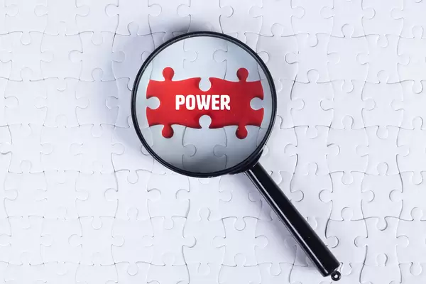Magnifying glass over missing puzzle with a text Power