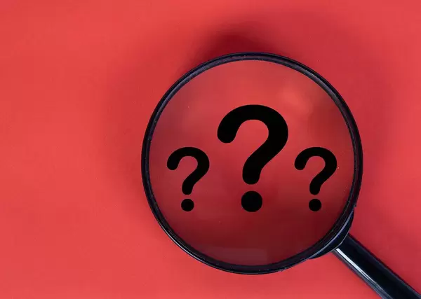 Magnifying glass over question mark symbols