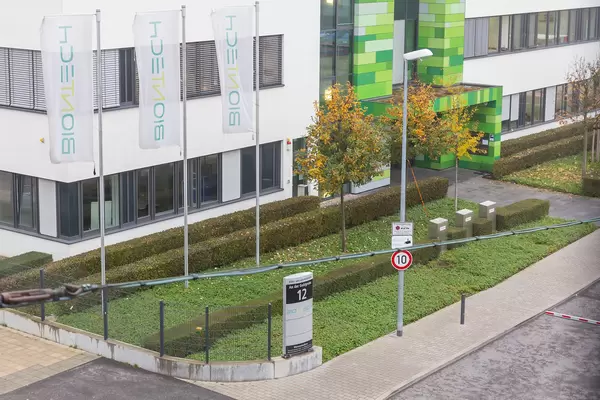 Main Entrance of BioNTech Headquarters with Flag Poles and BioNTech Flags in front of it in Mainz, Germany