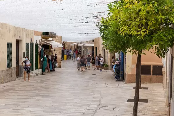 Majorca, summer 2020: tourists walking with face mask in Alcudía's old town with street decoration