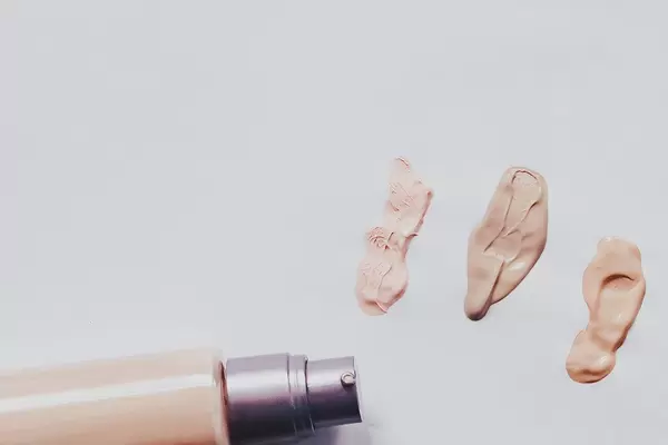 Make-up-Abstriche von cremefarbener Foundation auf weißem Papier als Hintergrund