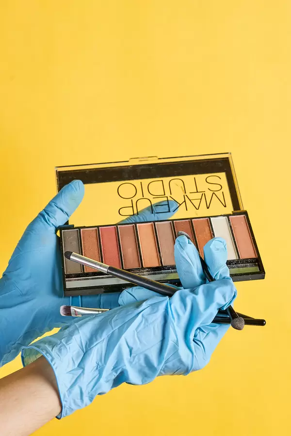Make-up artist hands hold blush and brush