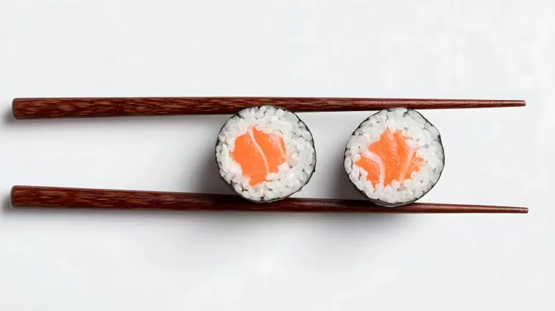 Maki Sushi mit Lachs und Essstäbchen auf weißem Hintergrund