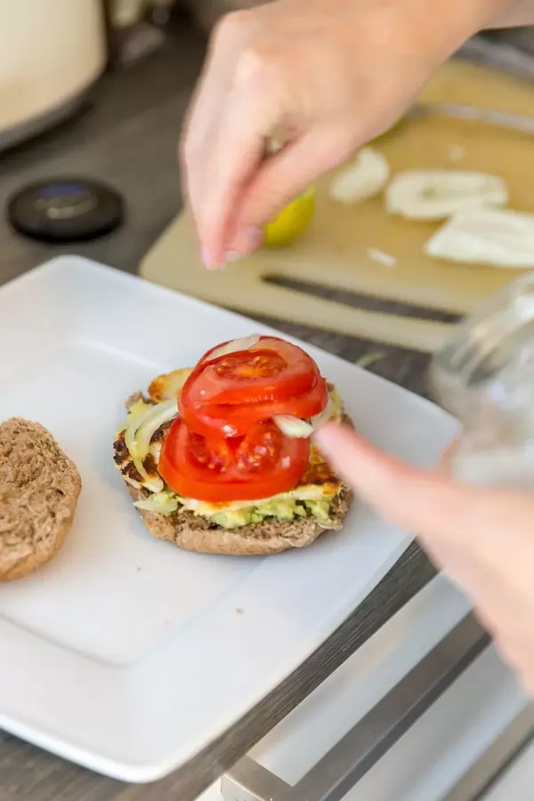 Making halloumi-cheese burger with avocado and tomato