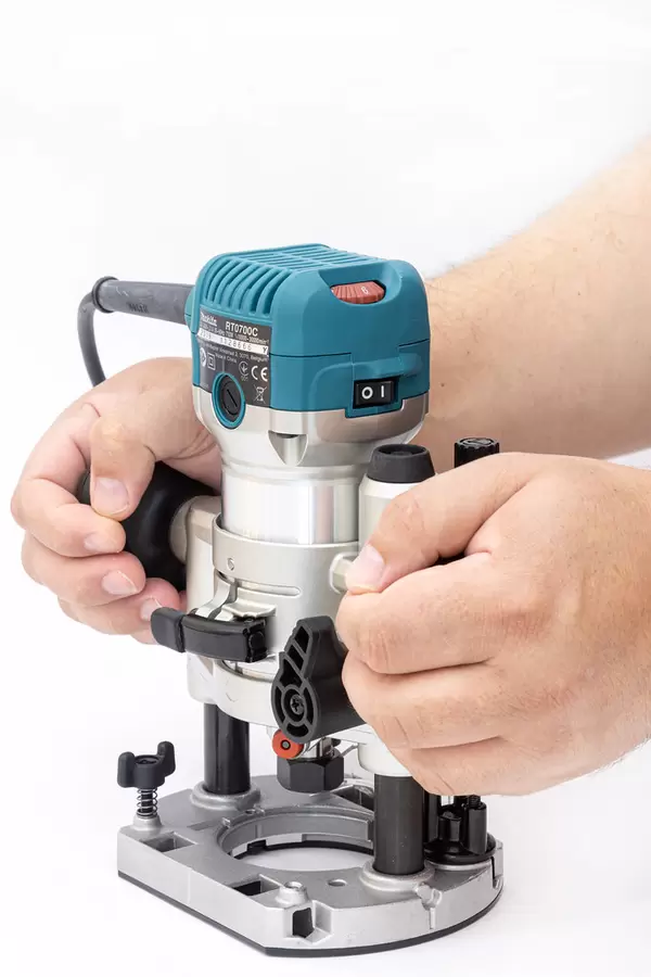 Makita Hand Router in the hands of the carpenter