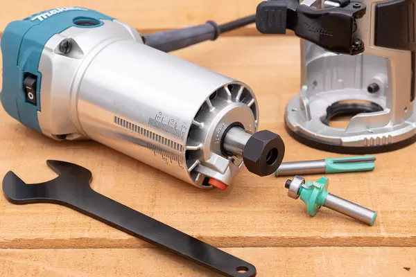 Makita Hand Router with Bits on the wooden table