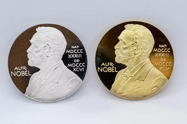 Makro-Fotografie: zwei Silber- und Goldmünzen mit dem Gesicht von Alfred Nobel
