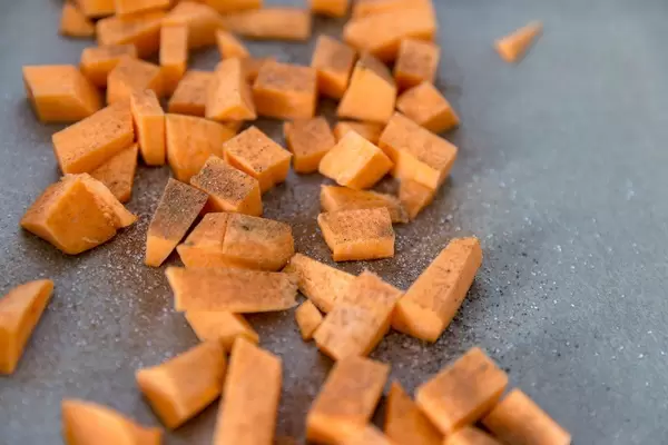 Makroaufnahme von Süßkartoffelwürfeln mit Zimt und Zucker