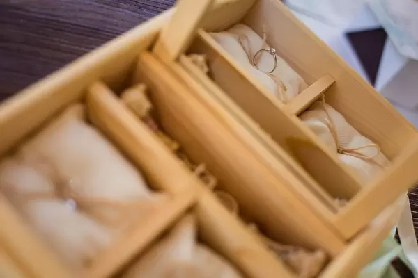 Makroaufnahme von Trauring auf Kissen in hölzerner Ringschatulle